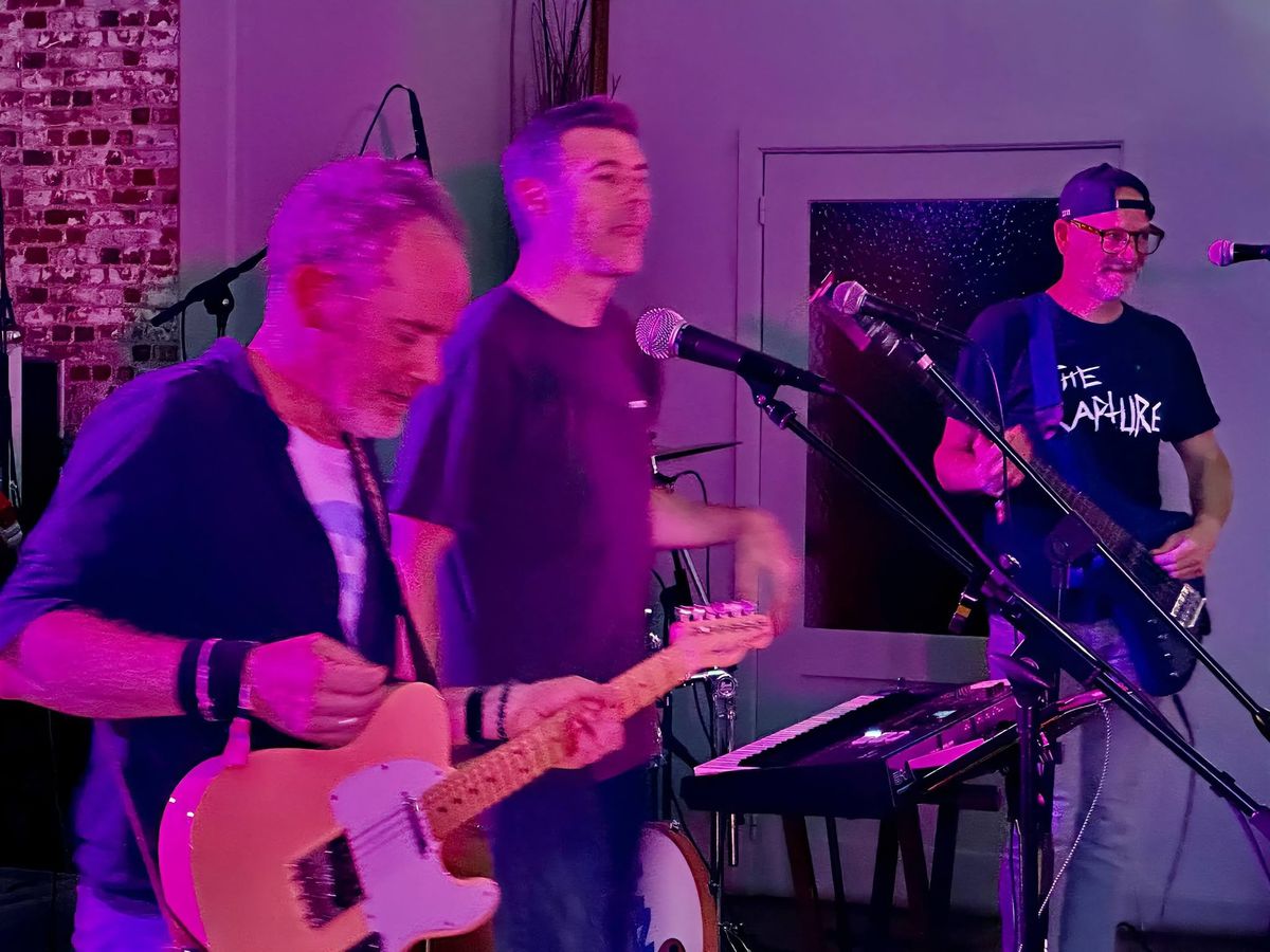 Le chanteur, le guitariste et le bassiste de The 40OZ en plein morceau