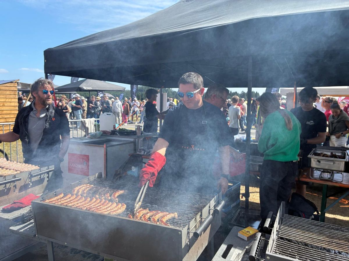 L'équipe au barbecue sous la tente, dans la fumée des saucisses