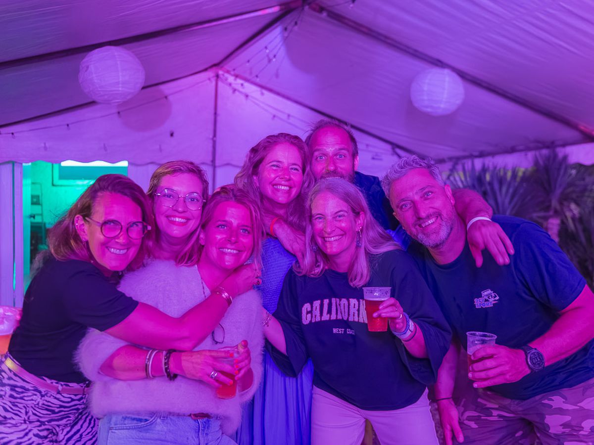 Des amis de l'équipe tout sourire sous la tente de la soirée WarmUp